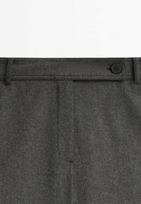 Grijze wollen broek met een gladde textuur, voorzien van een enkele zwarte knoopsluiting en klassieke zijzakken.
