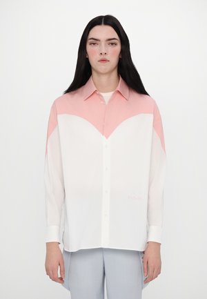 Button-up shirt with pastel pink and white panels, featuring a chevron design and subtle embroidery. Long sleeves with cuffs.