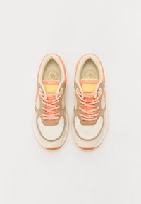 Beige and cream athletic shoes with mesh panels, orange accents, and textured laces. Round toe and rubber sole. Brand logo on tongue.