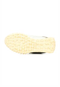 Scarpa sportiva bianca con una suola in gomma leggera gialla, caratterizzata da un texture con motivi circolari e scanalature per la presa, vista dal basso.