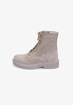 Beige suède enkellaarsjes met een vetersluiting aan de voorkant, ronde neus en een geprofileerde rubberen zool. Voorzien van metalen veterogen en een gevoerde kraag.