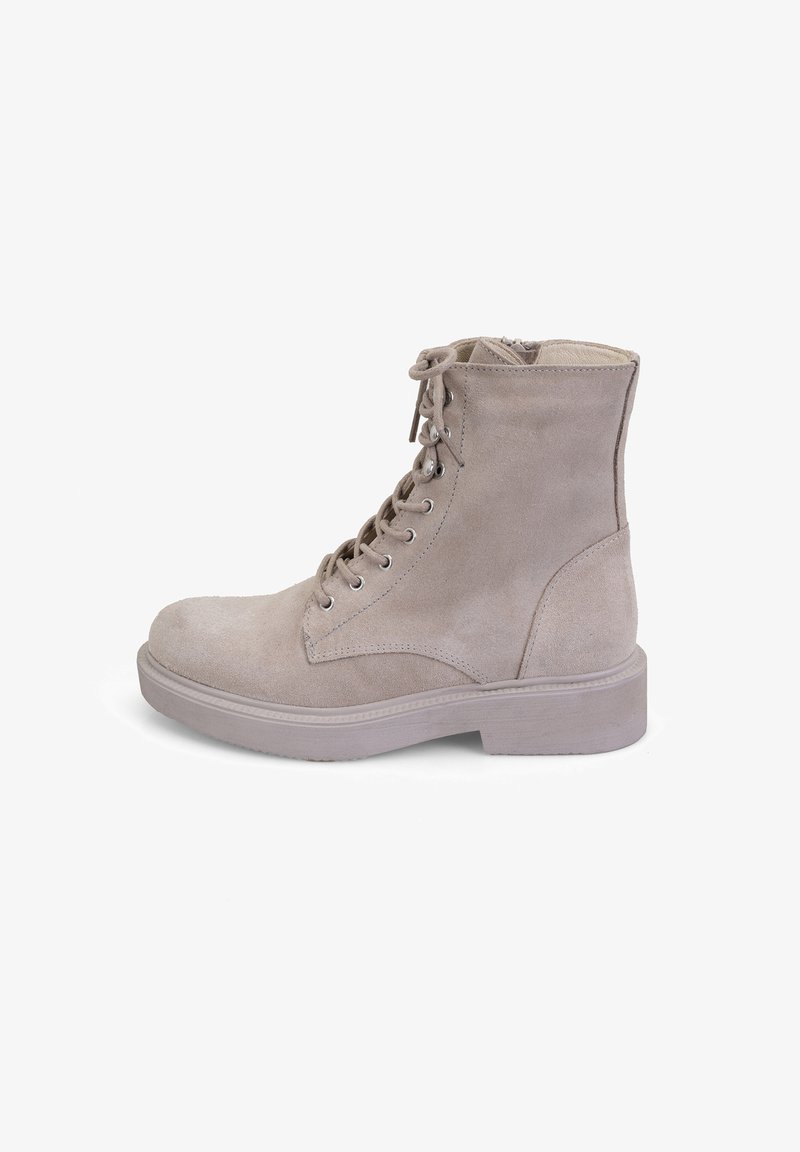 Beige suède enkellaarsjes met een vetersluiting aan de voorkant, ronde neus en een geprofileerde rubberen zool. Voorzien van metalen veterogen en een gevoerde kraag.