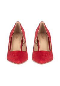 Red suede pointed-toe heels with a cut-out side design and a smooth beige interior. Stiletto heels add height.