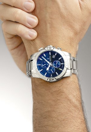 Orologio cronografo in acciaio inossidabile argentato con quadrante blu, tre sotto-quadranti e display della data. Il bracciale presenta un design a maglie.