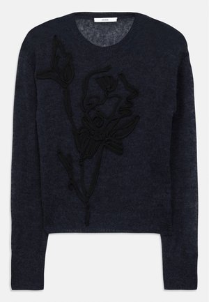 Navy blå sweater lavet af blødt garn med et struktureret sort blomsterbroderi på forsiden og en klassisk rund hals.