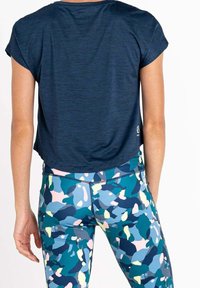 Top blu navy a maniche corte con vestibilità comoda, abbinato a leggings multicolori con motivi nei toni di blu, verde, rosa e giallo.