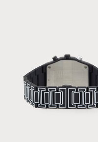 Ceas din silicon negru cu un model geometric, având accente albe, un cadran rectangular și spate din oțel inoxidabil.