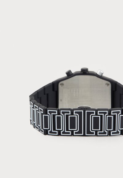 Orologio in silicone nero con un motivo geometrico che presenta accenti bianchi, un quadrante rettangolare e un retro in acciaio inossidabile.