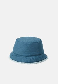 Lappet bøttehatt i teal med en strukturert overflate og en fluffy, lyseblå kant langs kanten. Sylinderformet med en bred skjerm.