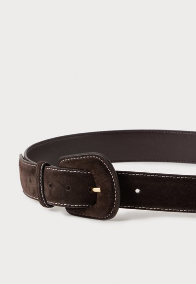 Ceinture en daim marron foncé avec boucle dorée et détail de couture blanche, posée à plat sur un fond clair.