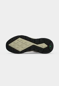 Σόλα παπουτσιού Timberland με μαύρο και μπεζ πέλμα, μοτίβα σε σχήμα σταυρού και το λογότυπο Timberland κοντά στη φτέρνα.