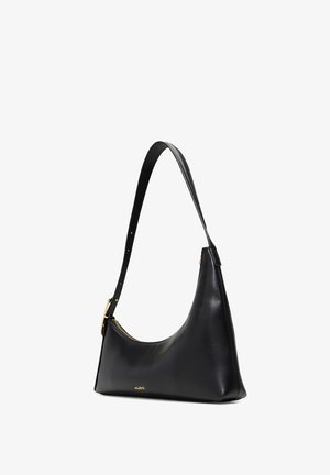 Bolso de hombro de cuero negro con forma curvada, una correa larga y ajustable, y sutiles detalles en dorado. Presenta una textura suave y un minimalismo en la marca.