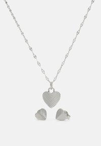 Ensemble de bijoux en argent comprenant un collier en chaîne avec un pendentif en forme de cœur strié et des boucles d'oreilles à clou assorties, tous deux présentant un design texturé.