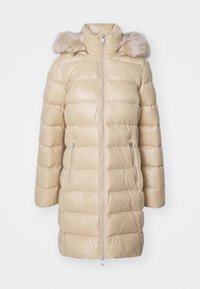 Beige kviltad lång puffjacka med framdragkedja, två fickor med dragkedja, hög krage och avtagbar huva med pälsdetaljer.