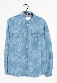 Camicia di jeans azzurro chiaro con motivo paisley, due tasche sul petto, chiusura con bottoni e maniche lunghe con polsini abbottonati.