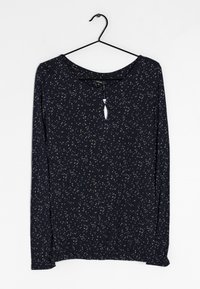 Marinblå långärmad topp med vita och beige utspridda prickar, rund halsringning, nyckelhålsdetalj fram, och elastisk nederkant.