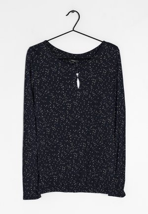 Marineblaues Langarmoberteil mit einem Muster aus weißen und beige verstreuten Punkten, runder Ausschnitt, Schlüsselloch-Detail vorne und elastischem Saum.