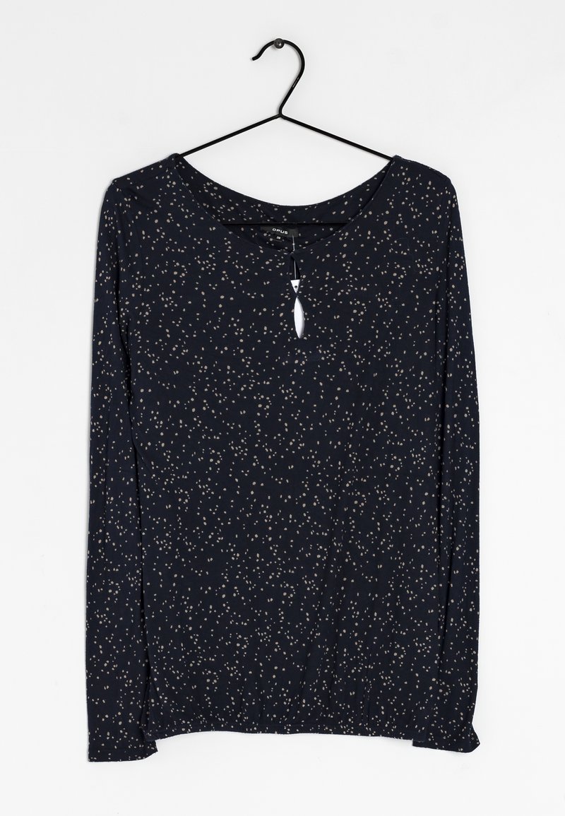 Marinblå långärmad topp med vita och beige utspridda prickar, rund halsringning, nyckelhålsdetalj fram, och elastisk nederkant.