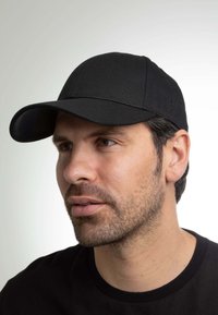 Cappellino da baseball nero con visiera curva, realizzato in tessuto liscio. Presenta un logo discreto sul lato e un design aderente.