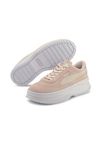 Baskets en daim rose clair avec semelle en caoutchouc blanche, motif texturé sur la semelle extérieure et détail du logo sur le côté. Lacets et col rembourré pour le confort.