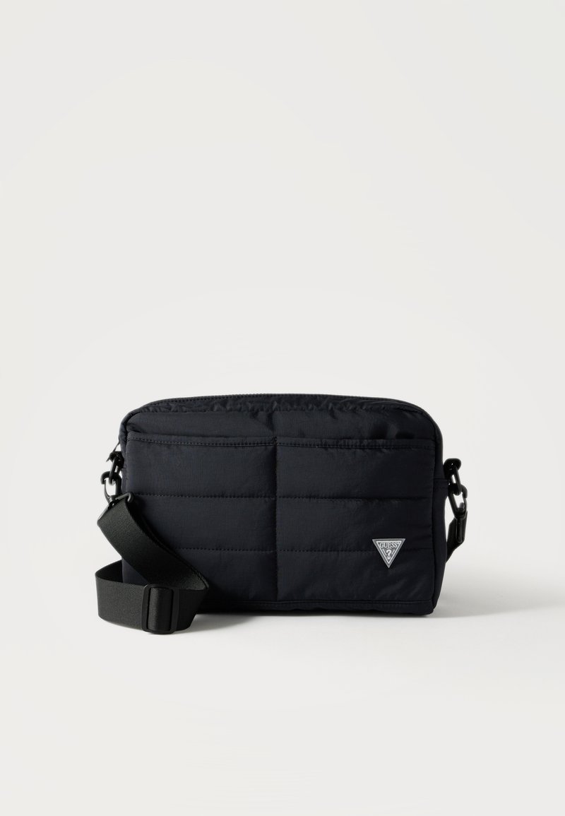 Μαύρη καπιτονέ ορθογώνια τσάντα χιαστί με ρυθμιζόμενο λουρί και μικρό τριγωνικό λογότυπο μάρκας στο μπροστινό μέρος, απεικονισμένη σε λευκό φόντο.