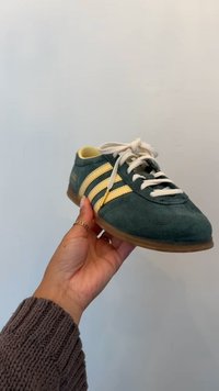 Roheline sametist spordijalats kollaste triipudega, valgete paelte ja kummist tallaga. Ümardatud ninaga ja minimaalne brändimisega külgedel.