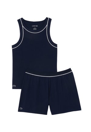 Merinavyyninen toppi ja shortsit, valmistettu ribatusta kankaasta, joissa on valkoiset pipingsivut ja Lacoste-logo brodeerattuna shortseissa.
