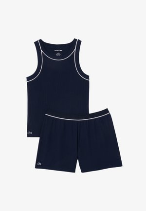 Marine tanktop en short set, gemaakt van ribbelstof, met witte piping accenten en een geborduurd Lacoste logo op de short.