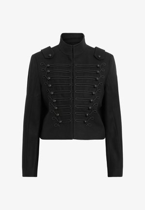 Schwarze cropped Jacke mit Stehkragen, aufwendiger Knopfleiste mit geflochtenen Details und Schulterklappen.