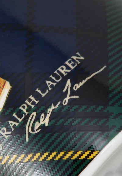 Ralph Laureni logo ja scripti autogramm sinise ja rohelise ruudulise mustriga pinnal, millel on kollased aktsendid.