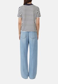 Gestreepte polo met korte mouwen in marineblauw en wit, gecombineerd met lichtblauwe hoge taille wijde jeans met achterzakken en een relaxte pasvorm.
