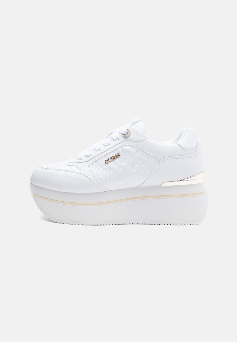 Sneaker piattaforma bianca con pannelli laterali trapuntati, logo metallizzato "Guess", chiusura con lacci e suola spessa con delicata striscia beige e accento dorato.