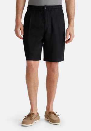 Pantalones cortos negros confeccionados en un material ligero con una cintura elástica, que cuentan con un cierre de botón y bolsillos laterales. Ajuste informal.