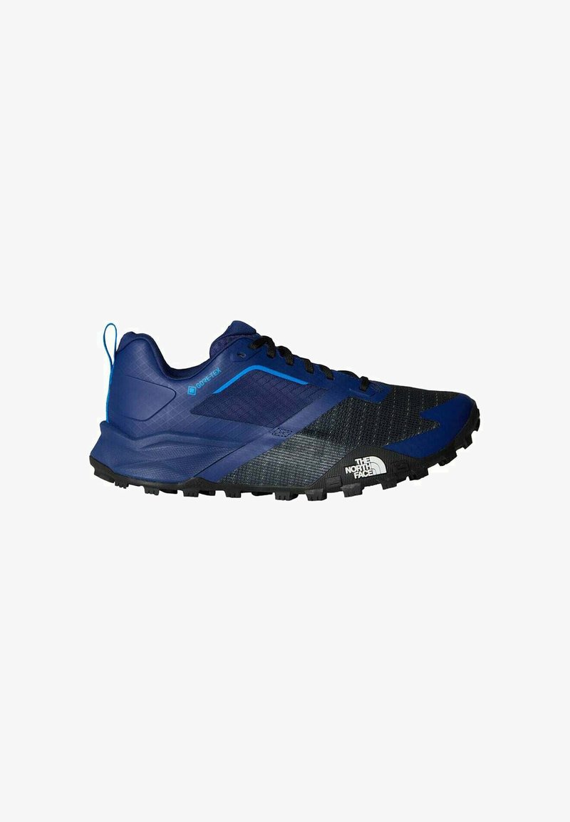 Scarpe da trail running blu e nere con tomaia in mesh testurizzato, marchio Gore-Tex, suola in gomma e battistrada a tasselli per una migliore aderenza.