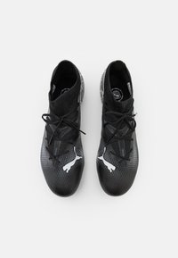 Scarpe sportive nere con una parte superiore testurizzata, lacci separati e accenti bianchi del logo. Presentano un design elegante e un materiale flessibile.