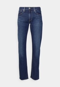 Tmavě modré džíny z denimu s přímým střihem nohavic, vybavené zapínáním na přední knoflíky, poutky na opasek a jemným vyblednutím na stehnech.