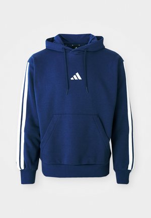 Marineblå hettegenser laget av mykt stoff, med en frontlomme, hvite stripete detaljer på ermene, og en hvit logo på brystet.