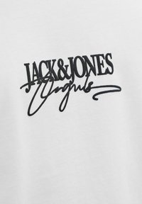 Baltas medvilninis marškinėlis su išskirtiniu juodu siuvinėjimu, kuris skelbia "JACK & JONES" su dekoratyviu rašteliu.