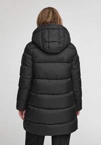 Czarna puchowa kurtka z wysokim kapturem, charakteryzująca się pikowanym wzorem i poziomymi sekcjami. Tkanina ma gładką fakturę i błyszczące wykończenie.