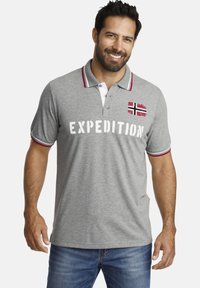 Graues Polo-Shirt mit roten Akzenten. Mit einem norwegischen Flaggenpatch und dem weißen Text "EXPEDITION". Aus Baumwolle, kurze Ärmel und mit Kragen.