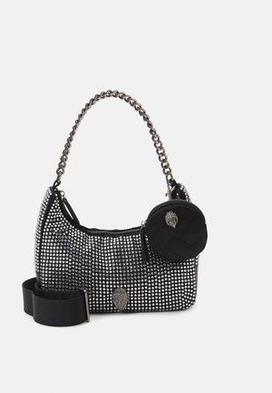 Sac à main noir orné de clous argentés, avec une anse chaîne épaisse, une large bandoulière amovible et une petite pochette ronde zippée attachée.