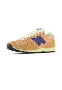 Orangefarbener und pinker Wildledersneaker mit einem lila Logo, strukturiertem Obermaterial, cremefarbenen Schnürsenkeln und einer schwarzen Gummiaußensohle. Abgerundete Spitze und flaches Design.