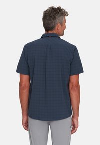 Koszula z krótkim rękawem zapinana na guziki w ciemnoniebieskim kolorze z wzorem kratki. Posiada standardowy kołnierz i prosty krój. Miękka, lekka tkanina.