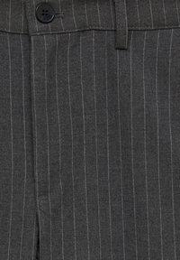 Tissu de costume gris foncé à fines rayures avec détail de bouton noir et passants de ceinture, mettant en valeur une fine couture blanche verticale.