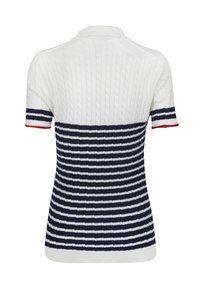 Polo à manches courtes en blanc avec une texture tricot cable en haut, passant à des rayures horizontales bleu marine et blanches en bas, avec des accents rouges.