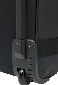 Black luggage with a textured fabric surface, a robust wheel assembly, and a reinforced corner. Features include a secure fastening strap and smooth wheels.