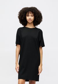 Black short-sleeve dress with a loose fit and round neckline, crafted from smooth fabric, falling to mid-thigh length.