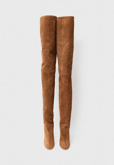 Botas de ante marrón de muslo alto con una textura suave, forma ajustada, punta abierta y borde superior redondeado para una silueta elegante.