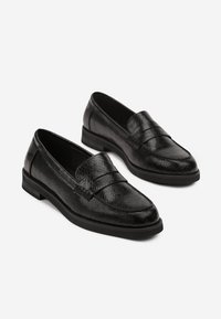 Mocassins en cuir noir avec un motif de serpent texturé, bout rectangulaire et semelle plate. Équipés d'une large sangle sur le cou-de-pied.