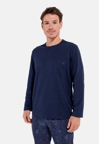 Marineblaues Langarmshirt aus Baumwolle mit rundem Ausschnitt, ausgestattet mit einer kleinen Brusttasche und einem dezenten Logo-Detail.